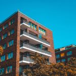 Brick apartment house with warm colored trees