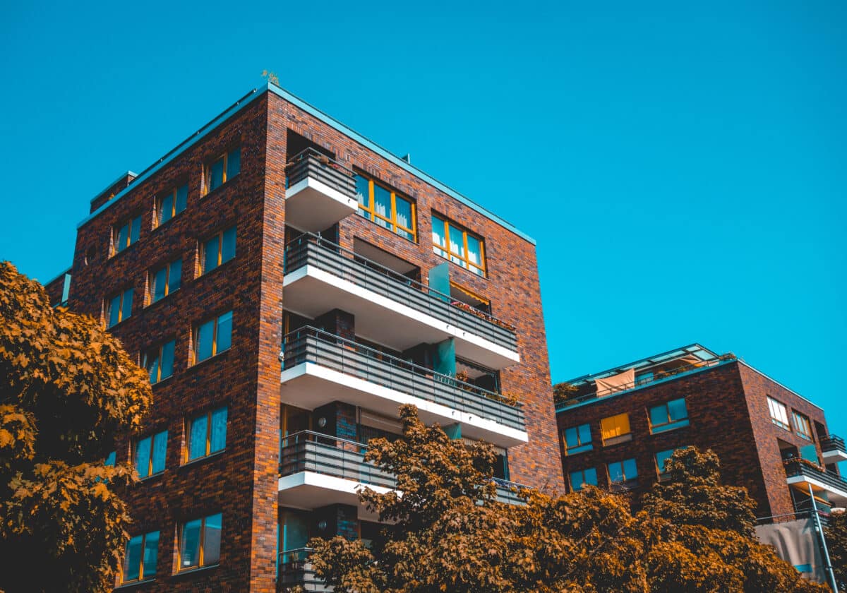 Brick apartment house with warm colored trees